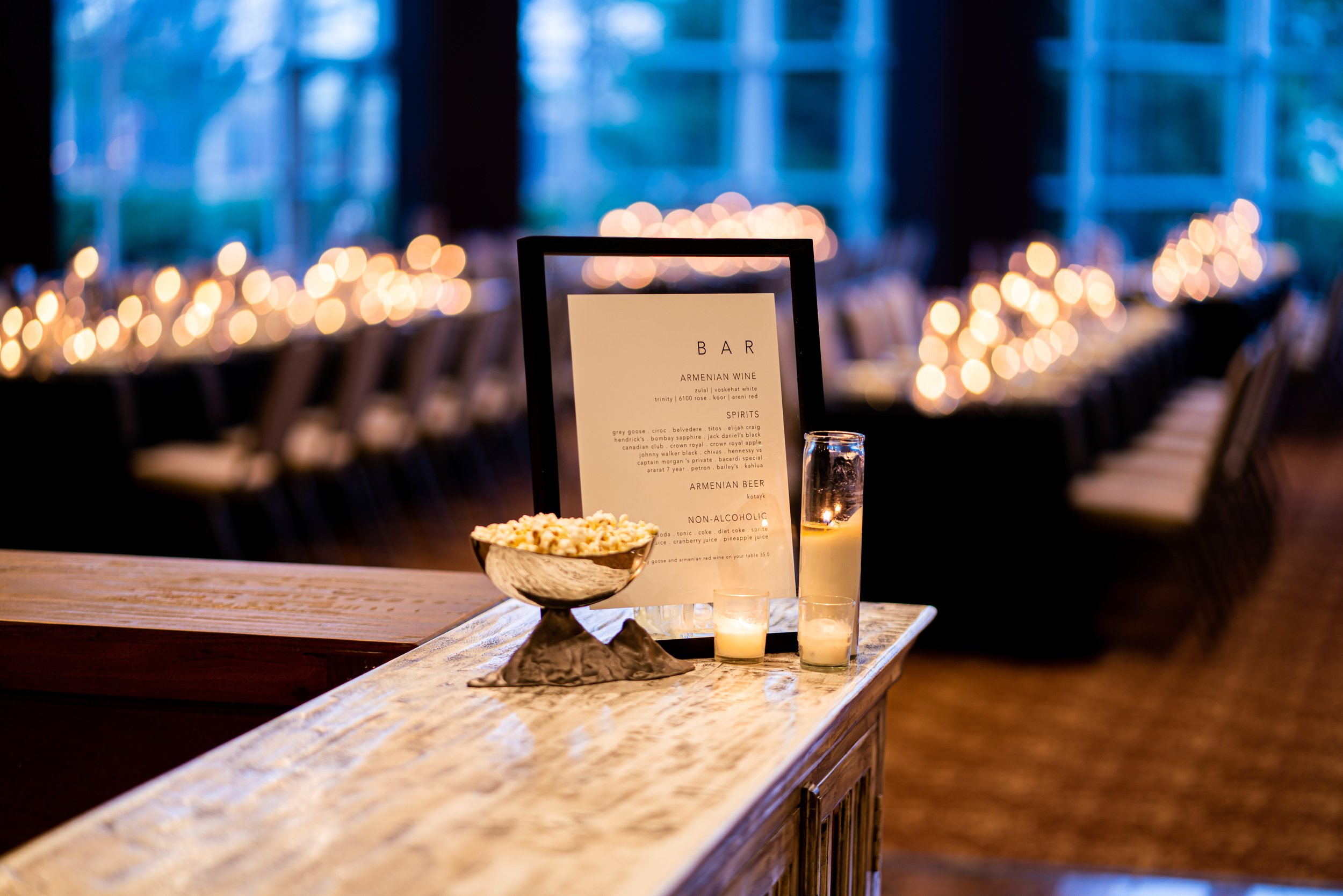A candlelit bar setup with the evening's drink menu