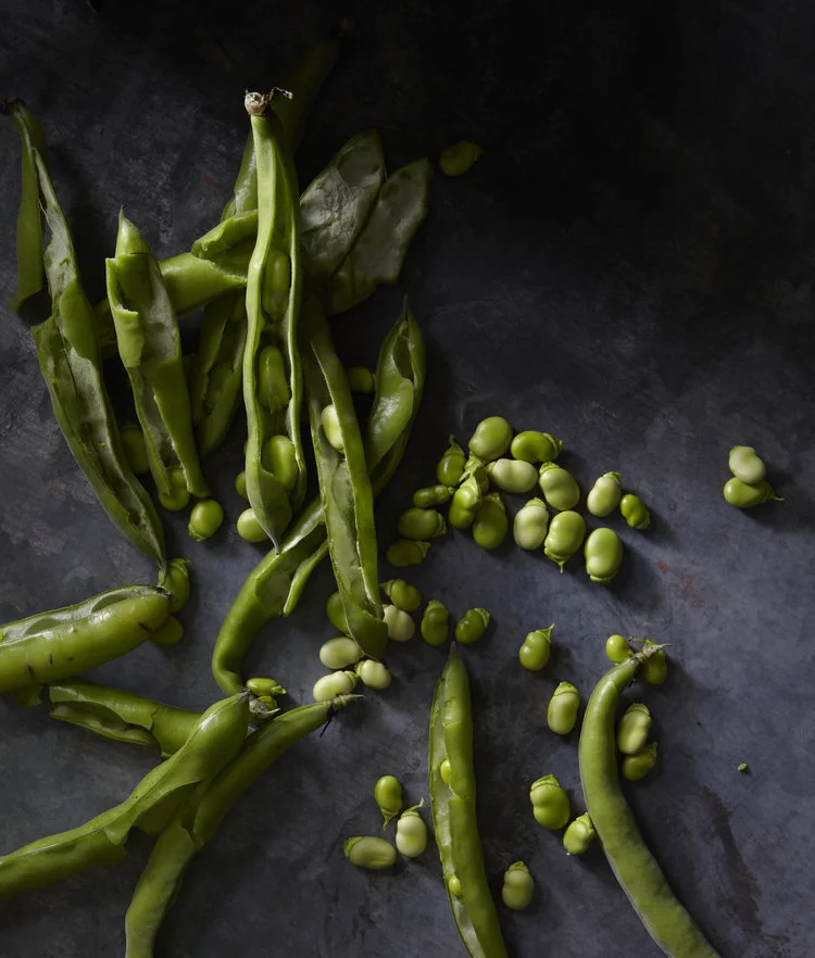 Fresh fava beans being shucked in the kitchen